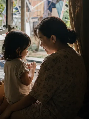 Parent listening closely to a child by the window