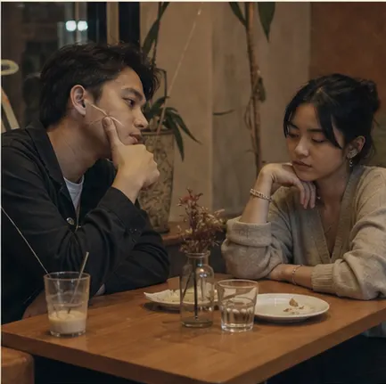 dua orang duduk di cafe dengan diam yang hangat